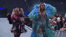two women are walking in front of a crowd with a w logo on the bottom