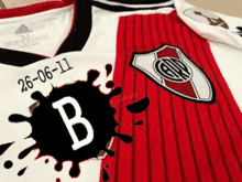 a red and white jersey with the letter b on the front