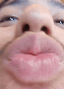 a close up of a man making a funny face with his lips .