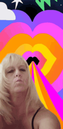 a woman with blonde hair is standing in front of a rainbow heart