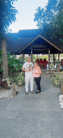 a man and a woman are standing in front of a building