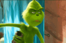 a green cartoon character is standing in front of a blue curtain