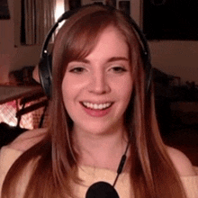 a woman wearing headphones and a microphone smiles