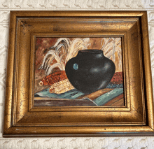 a painting of a black vase surrounded by corn in a gold frame