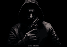 a man in a hooded jacket is holding a gun in his hand