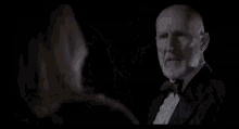 a man in a suit and bow tie holds a woman 's legs