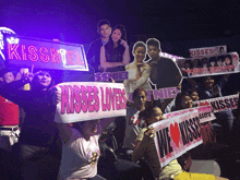 a group of people holding up signs for kisses lovers