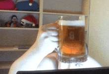 a person is holding a glass of beer with the number 8 on it