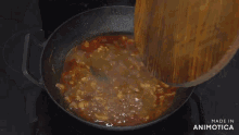 a man is stirring a pot of food in a kitchen with the words made in animatica on the bottom right