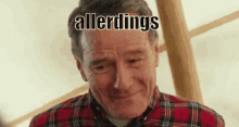 a man in a plaid shirt is smiling and making a funny face with the words allerdings written on his face .