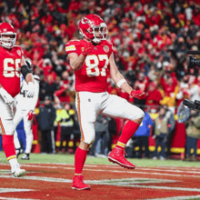 a football player with the number 87 on his jersey celebrates on the field