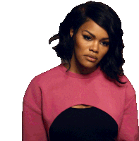 a woman wearing a pink sweater and a black top is looking down