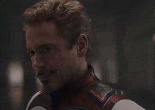 a close up of a man with a beard wearing a superhero outfit