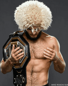 a man holding a ufc championship belt in his hands