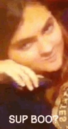 a close up of a woman 's face with the words sup boo written on it