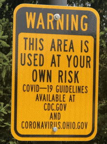 a yellow and black warning sign that says this area is used at your own risk