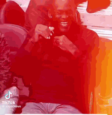 a man is sitting in a chair and smiling while holding a ring .