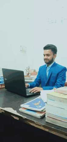 a man in a blue suit is working on an acer laptop