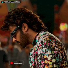 a man wearing sunglasses and a floral shirt is on a youtube music advertisement