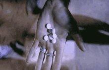 a person holding a handful of pills in their hand