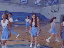 a group of cheerleaders are standing on a basketball court in front of a bleacher that says pioneers on it