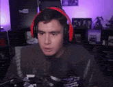 a man wearing red headphones is talking into a microphone .