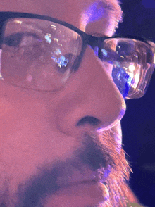 a close up of a man 's face with glasses