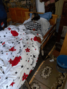 a person is laying in a bed with a blanket that has flowers and stars on it