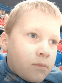 a close up of a young boy 's face with blue eyes