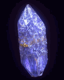 a close up of a purple crystal with gold in the center