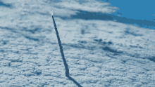 a rocket is flying through the clouds with a flame coming out of it