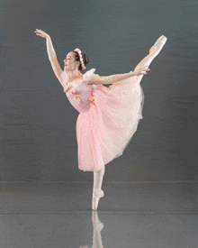 a ballerina in a pink dress and white pointe shoes