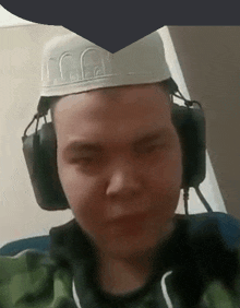 a man wearing headphones and a hat with a crown on it