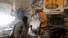 a person painting in a kitchen with graffiti on the walls