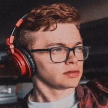 a young man wearing glasses and headphones looks to his left