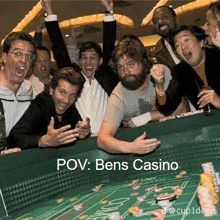 a group of people are playing roulette in a casino and laughing .