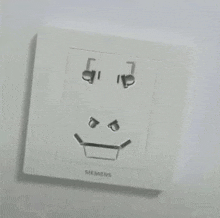 a siemens electrical outlet with a smiley face drawn on it