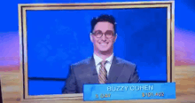 a man in a suit and tie is on a television show called buzzy cohen .