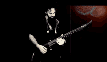 a man with a beard is playing a guitar with the brand name ibanez on it