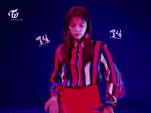 a woman in a striped shirt and red skirt is standing in front of a blue background that says twice tv