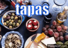 a table topped with a variety of tapas including grapes olives and cheese