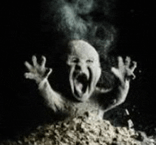 a statue of a baby with its mouth open is coming out of a pile of food .