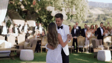 a bride and groom are dancing in front of their wedding guests and the word people is on the bottom right