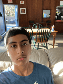 a boy is sitting on a couch in front of a wooden exit sign