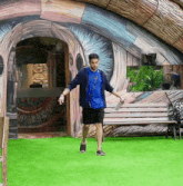 a man in a blue shirt is walking in front of a giant eye painting