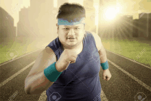 a fat man wearing a blue headband and wristbands is running on a track