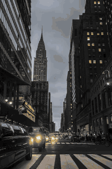 a black and white photo of a busy city street with a chrysler building in the background