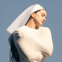 a woman in a white dress with a white veil around her head