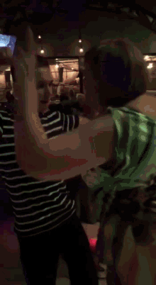 a man in a striped shirt is standing next to a woman