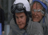 two men wearing helmets and goggles are posing for a photo